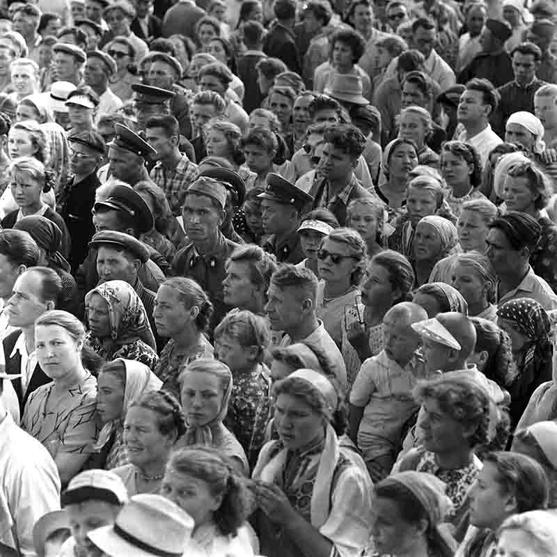 Schwarz-Weiß-Fotografie von Peter Bock-Schroeder aus dem Jahr 1956: Besucher flanieren über das weite Gelände der Moskauer Landwirtschafts- und Industrieausstellung (WNSCh/VDNKh) vor imposanten Pavillons im Stil des sozialistischen Klassizismus.
