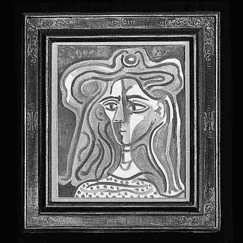 Ein Schwarz-Weiß-Foto des kubistischen Gemäldes „Buste de femme“ von Pablo Picasso, eingefasst in einen aufwendig verzierten, dunkel geschnitzten Holzrahmen. Das Porträt zeigt eine Frau im abstrakten Stil mit gewelltem, stylisiertem Haar, das ein gespaltenes Gesicht mit asymmetrischen Zügen und großen, mandelförmigen Augen umrahmt. Sie trägt ein gemustertes Oberteil mit hellen Punkten oder kleinen Figuren vor einem dunklen Hintergrund.